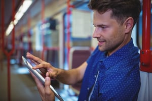 man using digital tablet while travelling in train - content audit increase your manufacturing organic Google rankings.