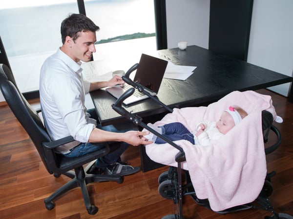 effective remote working a young man parent working on laptop computer at home office and take care of baby