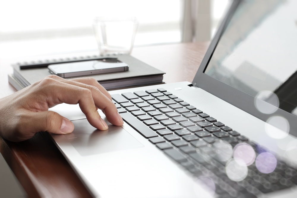Close up of business man working on laptop computer on wooden desk as concept