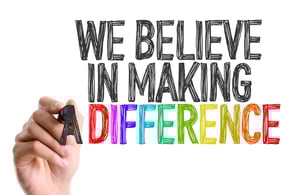 Hand with marker writing We Believe in Making a Difference